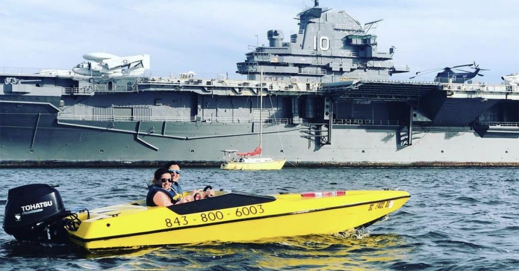 Couple rents a speedboat in Charleston—pose in front of the YSS Yorktown.