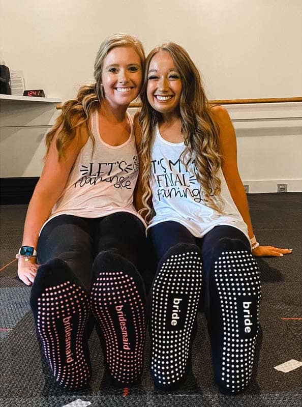 Baley and one of her bridesmaids taking a photo with matching socks.