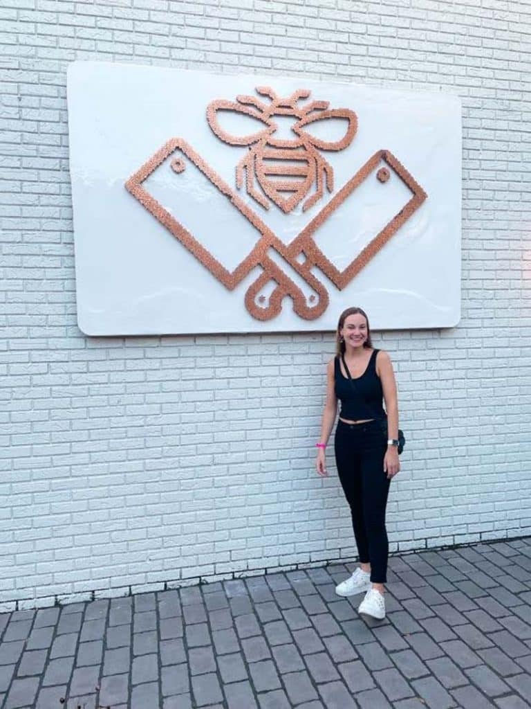 Samantha Testa under the butcher and bee sign.